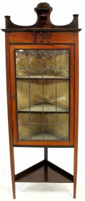 An Edwardian mahogany and line inlaid flat-fronted freestanding corner cupboard with open top shelf above single leaded glazed door and raised on square tapering supports united by an undertier, width 61cm, height including upper shelf 180cm, depth from corner to front approx 37cm.