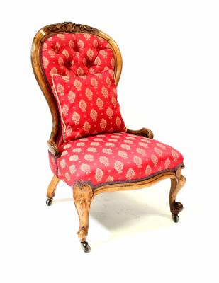A Victorian walnut spoon back chair with carved decoration, with serpentine front on cabriole legs, upholstered in a woven red fabric.