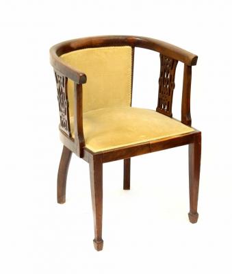 An Edwardian mahogany tub chair supported by shaped pierced spindles, upholstered seat, raised on square tapering front supports.