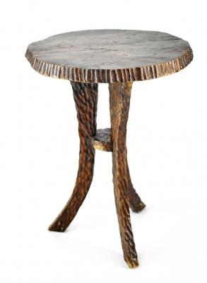 A small rustic locally hand-carved stool of simple form with shaped top above three outswept supports united by a central circular stretcher, diameter 25cm, height 35cm.