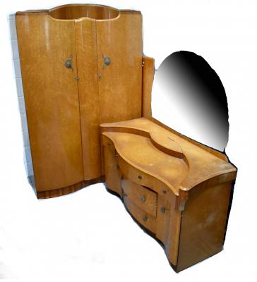 An early 20th century bird's-eye maple bedroom suite comprising double bow-fronted wardrobe, a matching dressing table with shaped front above a T-formation of drawers flanked by cupboard doors and a double headboard (3).