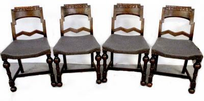 A set of four 1930s oak dining chairs with carved back rests and studded upholstered seats, on turned legs (4).