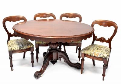 A Victorian mahogany oval tilt-top dining table on bulbous carved supports and tripod base and four Victorian mahogany balloon-back dining chairs upholstered in butterfly material, length 135cm (5).