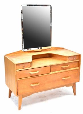 A G-Plan light oak dressing table designed by E Gomme, of rectangular form with rectangular mirror above four short and one long drawers, on square tapering legs, maker's stamp within small drawer, 141 x 106cm x 46cm.