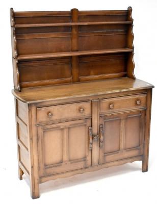 An Ercol dark stained elm dresser with enclosed plate rack above a base of two drawers and two cupboard doors, on stile feet, 151 x 123 x 44cm.