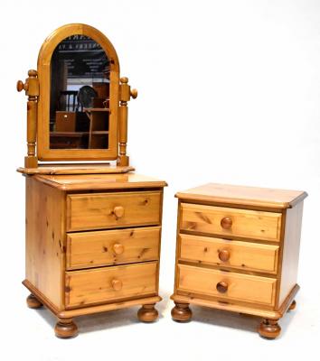 A pair of waxed pine bedside tables, each with three drawers, on bun feet and castors, heights 60cm and 55cm, width of each 46cm, depth of each 44cm and a similar arch top swing toilet mirror, height 64cm, width 52cm (3).