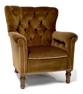A 1930s walnut button-back armchair upholstered in brown velour and on turned feet.