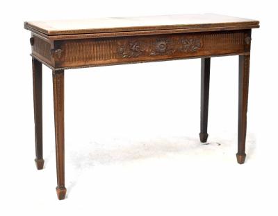 A good 19th century mahogany tea table of rectangular form with fold-over top and carved frieze with sunflower and scrolling foliate detail, on square tapering carved legs with spade feet, 77 x 107 x 44cm (af).