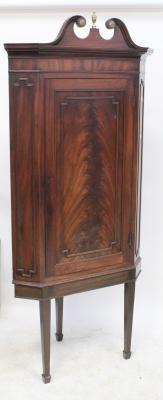 A 19th century mahogany floorstanding corner cupboard with broken swan neck pediment above a single panelled door enclosing three shaped shelves, on a matched base with square tapering legs (converted from a wall hanging cabinet), approx 200 x 89 x 50cm.