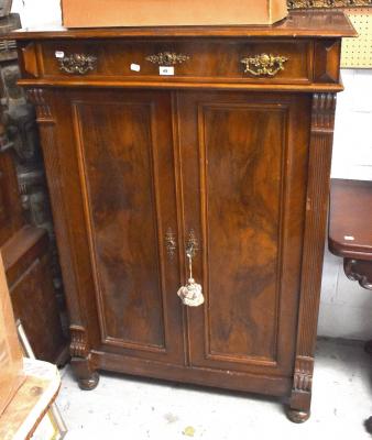 A Victorian mahogany cabinet with a single drawer above a pair of panelled cupboard doors enclosing three shelves, flanked by reeded pilasters, on turned feet, 133 x 94 x 48cm.