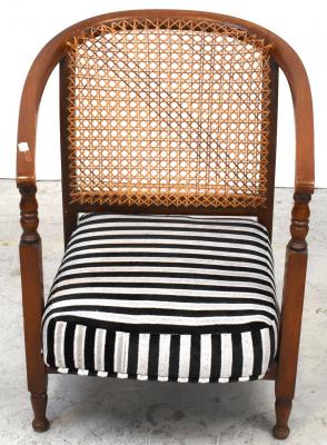 An Edwardian mahogany bergère back low chair to turned supports.