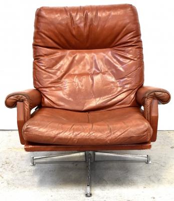 H K Furniture Ltd; a Howard Keith designed mid-century retro tan leather swivel lounge chair raised on chrome four-legged base.