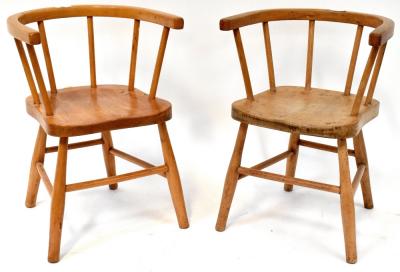 Two children's Windsor-style chairs of matching design, with solid saddle seats, curved back, spindle sides united by spindle cross-stretchers, height 49cm (2).