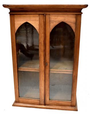 A small tabletop pine bookcase with pair of arched glazed doors raised on plinth base, 76 x 53 x 24cm.