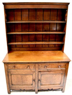 An early 19th century oak dresser, the boarded plate rack above base of two short drawers and two panelled doors to stile supports, 181 x 127 x 54cm.