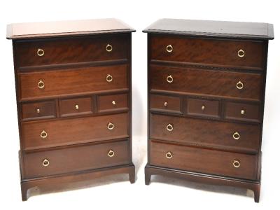 A pair of Stag Minstrel dark stained chestS of drawers, each with four long and three short drawers, on bracket feet and ring handles, 112 x 46.5 x 82.5cm.