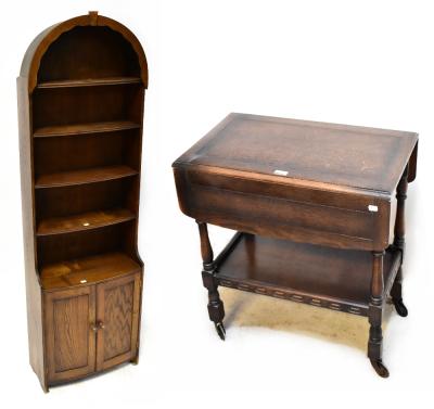 An Edwardian oak drop-leaf two-tier tea trolley on castors, length when extended 87cm and a 20th century oak floorstanding unit, four shelves above two bow front cupboard doors to plinth support, 174 x 53 x 25cm (2).