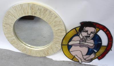 A large ivory-coloured abalone shell circular wall mirror, diameter 80.5cm and a stained glass panel of an infant child, diameter 63.5cm (af) (2).