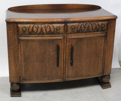 An early-to-mid 20th century oak bow-front sideboard, two frieze drawers over two cupboard doors to block supports, length 122cm.