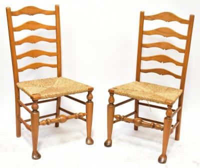 A set of six light oak reproduction Lancashire ladder back chairs, with rush seat united by bobbin turned stretchers, on front pad feet.