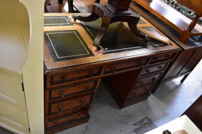 An early 20th century oak pedestal desk with five leather inserts to the top, over three small drawers, on two banks of three drawers with brass swing handles, 78 x 121 x 69cm.