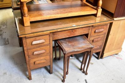 An early 20th century oak seven-drawer twin pedestal desk, with central drawer flanked by three drawers to either side, with pair of brush-in slides, raised on stile supports, 76 x 127 x 76cm, height of kneehole 60cm (af).