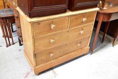 An early 20th century pine chest of two short over three long drawers, to plinth base and raised on turned bun feet, 78 x 97 x 44cm.