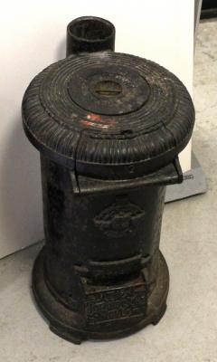 An early 20th century 'The Tortoise Stove Number 2' of cylindrical form with double-hinged front and removable hot plate, also bearing the 'C Portways Glow-Sure' patent badge, height 62.5cm.