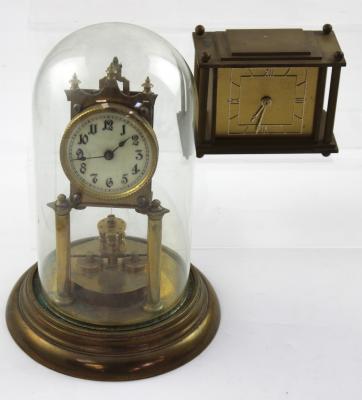 A small rectangular brass mantel clock, the dial set with Roman numerals and flanked by reeded columns, marked 'Davall British-made' to the back plate of the works, height 11cm and a brass anniversary clock with glass dome, height approx 27.5cm (2).