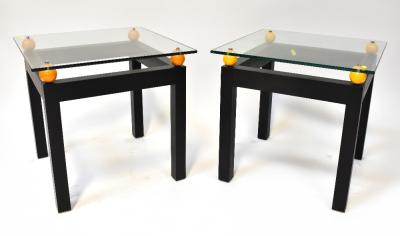 A pair of modern stylised glass top bedside/occasional/coffee tables, the square glass top suspended above four orange balls, one to each corner, mounted on black painted wooden square frame, each 52 x 54 x 54cm (2).