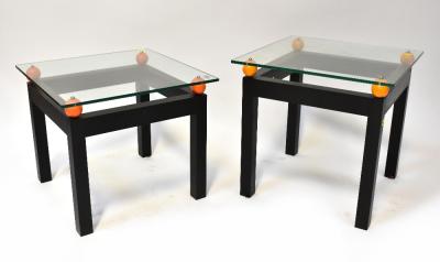 A pair of modern stylised glass top bedside/occasional/coffee tables, the square glass top suspended above four orange balls, one to each corner, mounted on black painted wooden square frame, each 52 x 54 x 54cm (2).