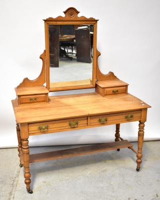 An Edwardian satin walnut dressing table, the mirrored back flanked by a pair of small jewellery drawers, above a pair of short frieze drawers, raised on turned stretchered supports united by an undertier, on brass caps and castors, 160 x 122 x 57cm (af).