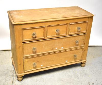 A Victorian pine chest of three short over two long drawers, with moulded glass handles, raised on turned supports, 87 x 110 x 48cm.