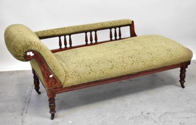 A Victorian mahogany framed chaise longue, scrolling back with curved side rail to carved frieze, tapering baluster supports to castors, 74 x 170 x 68cm.