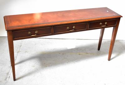 A reproduction mahogany line inlaid and crossbanded three-drawer side table, raised on square tapering supports, 69 x 138 x 33cm (af).