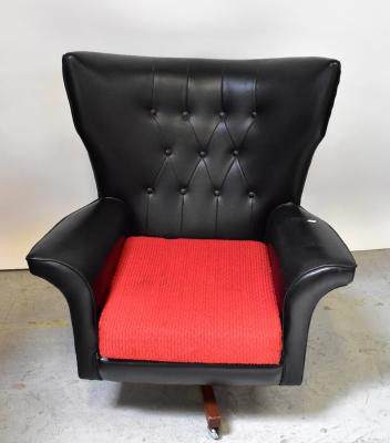 A mid-20th century leather button back swivel wing armchair, upholstered in black with later separate seat, raised on a teak four-prong base on castors, height 97cm.