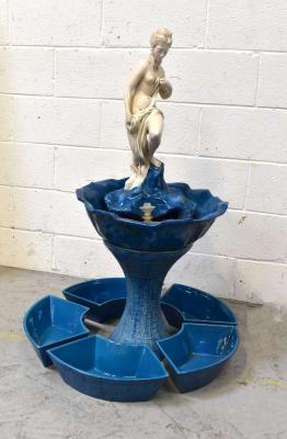 An interior water feature modelled as a semi-nude figure on rocks in flower head shaped dish, on bamboo-effect waisted column, surrounded by circular section trough decorated with bamboo-effect pattern, approx 100 x 66cm.