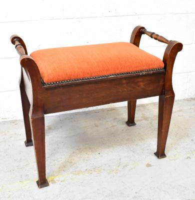 An early 20th century stained piano stool with upholstered hinged lid, flanked by pair of turned handles and raised on square tapering supports, 58 x 68 x 36cm.