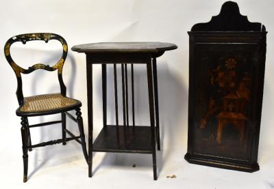 An early 19th century ebonised wall hanging corner cabinet in the Oriental style, with raised scenic village and figural decoration, 100 x 43 x 21cm, a Victorian ebonised bergère seat bedroom chair, with gilded and mother of pearl decoration depicting Chinese village scenes and a similar period ebonised two-tier table with Chinoiserie decoration of village and figural scenes to the top, floral vase and floral scene to the lower shelf, to four tapering supports, 70 x 60 x 40cm (3).