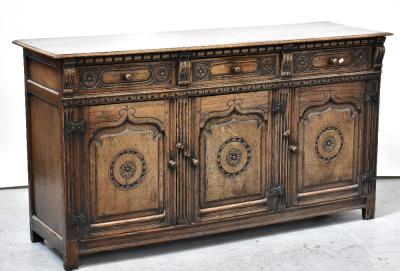 An early 20th century oak sideboard, the carved front comprising three drawers above three carved panel doors, raised on stile supports, 91 x 167 x 51cm.