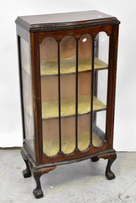 An early 20th century mahogany serpentine front display cabinet with single glazed door, raised on squat cabriole legs to ball and claw feet, 118 x 59 x 33cm.
