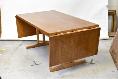 An early 20th century large oak drop-leaf table, cleated plank top set with drop leaves to the narrow end of the table, raised on stretchered supports, 74 x 172 x 92cm.