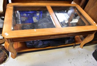 A large contemporary coffee table, the top set with two bevelled glass square panels, raised on reeded cabriole supports united by a solid undertier, 51 x 124 x 71cm.