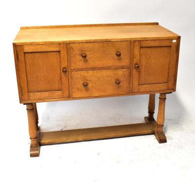 HEALS OF LONDON; an oak sideboard with a pair of drawers flanked by cupboard doors, on turned supports united by a stretcher, with ivorine label to inside of one of the doors, 90 x 112 x 45cm.