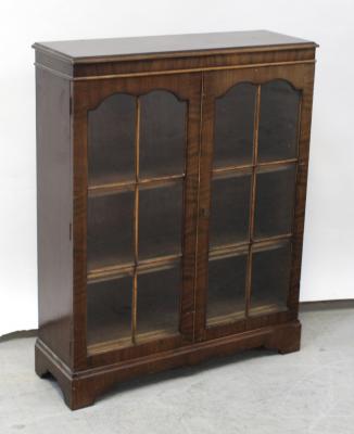 A small 20th century mahogany glazed bookcase on shaped plinth base, height 110.5cm.