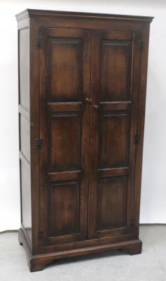 A reproduction oak two-door hall wardrobe with panelled sides, height 183cm.