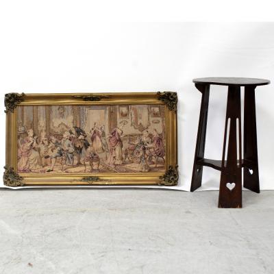 An early/mid-20th century oak provincial circular side table in the Arts & Crafts style, diameter 42cm and a contemporary framed tapestry panel depicting ladies and gentlemen in period costume taking tea, held within a gilded frame, 96 x 57cm (2).