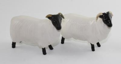 A pair of Beswick black-faced sheep, one finished in gloss, the other in matte, both marked to base, height approx 8cm (one af) (2).