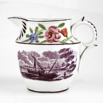 A Liverpool creamware jug with relief-moulded floral decoration to the neck and bat-printed boating scenes to either side in puce, height 10.5cm.