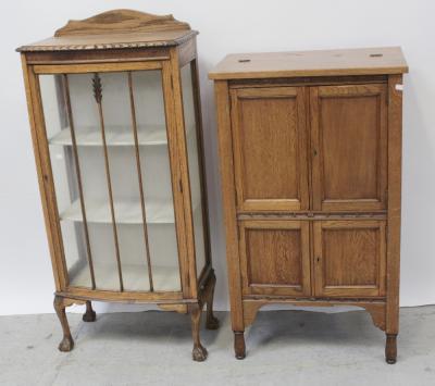 Am early/mid-20th century oak single-door display cabinet on cabriole legs to ball and claw feet, height 127.5cm and an oak tallboy cabinet with hinged top surmounting twin cupboard doors over a twin cabinet base (2).